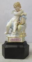 A 19th century Meissen figure, of a seated cherub leaning on a column, the triform base with pink