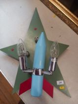 A wall light fitting, stylised as a rocket