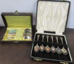 A cased set of six enamel coffee spoons, together with another set with enamelled thistle