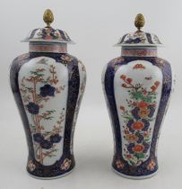 A pair of 20th century Chinese covered vases, decorated with panels of flowers, red seal mark to the