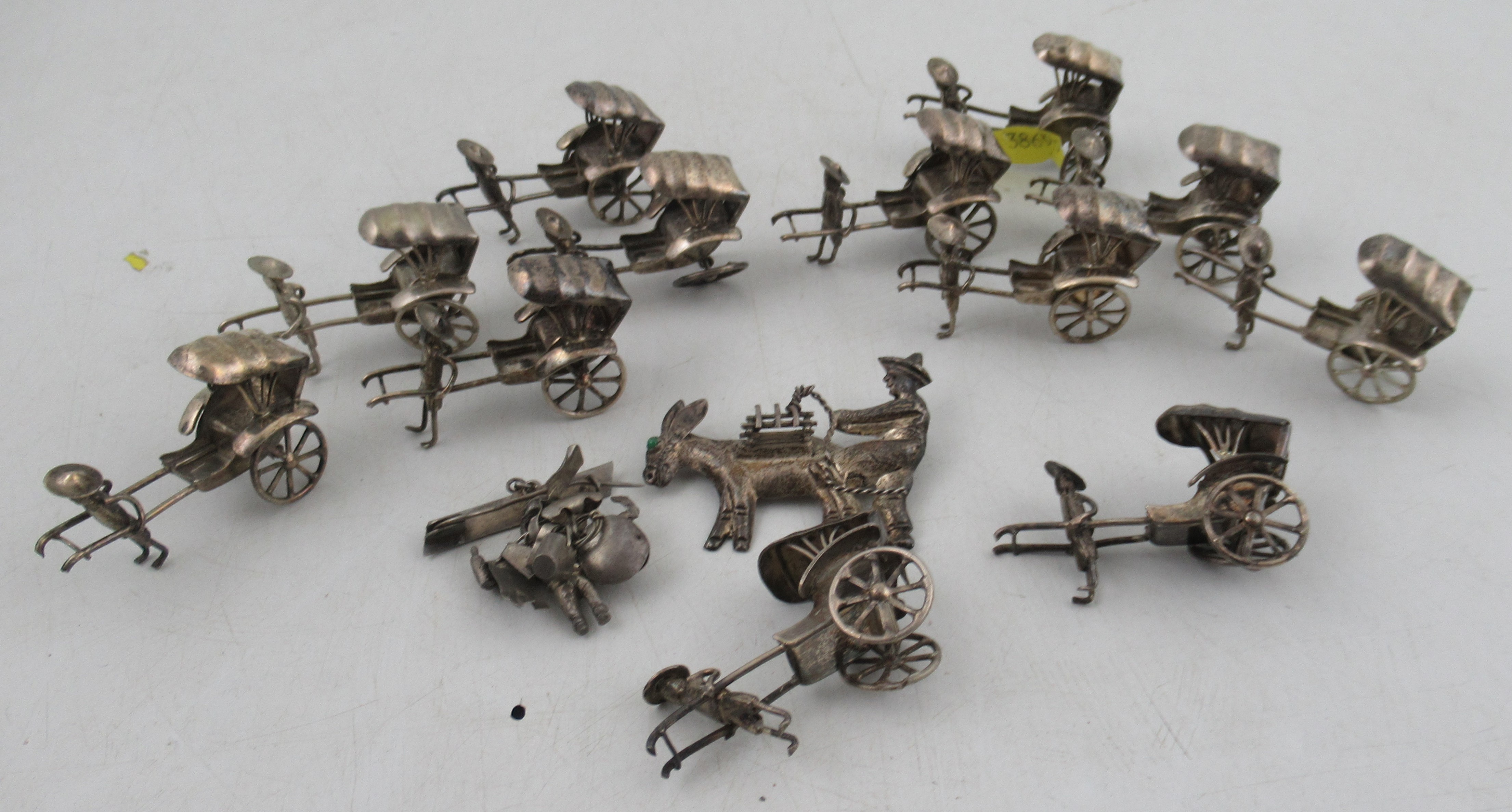 Twelve various white metal miniature Rickshaws with figures, together with a Mexican '925' silver