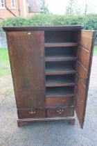 A Georgian mahogany press cupboard, having two cross banded doors, revealing five slide out trays