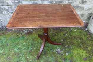 A rectangular cross banded occasional table, raised on a tripod base, 32.5ins x 31ins