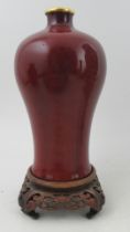 A sang de boeuf or red glazed meiping vase, of baluster form, with an associated later gilt collar