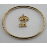 A 14k yellow gold engraved bracelet, together with a 14k gold palm tree and hut charm, weight 9.5g