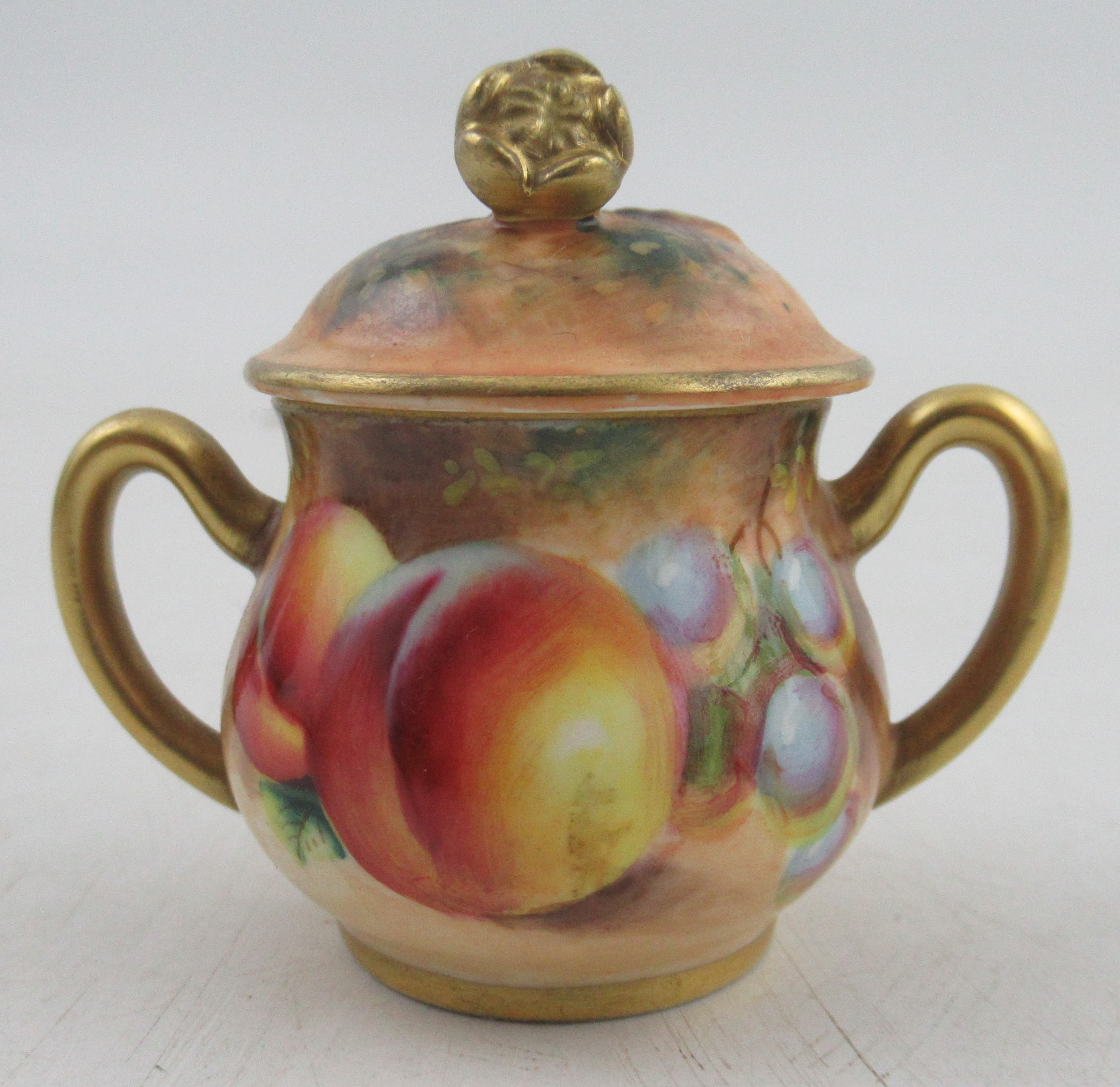 A Royal Worcester covered two handled sugar bowl, decorated with fruit by Roberts, height 2.25ins