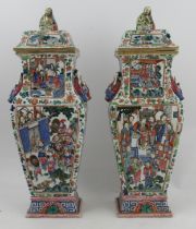 A pair of early 19th century covered Chinese temple vases decorated in colours with applied