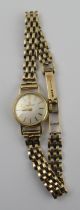A 9ct  gold Tissot Lady's watch, the dial with baton numerals and 9ct gold link bracelet, stamped '