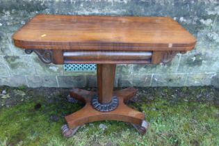 A 19th century rosewood fold over games table, raised on an octagonal column terminating in a