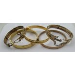 A gilt metal bangle, two other gilt bangles and two continental yellow and white metal bracelets