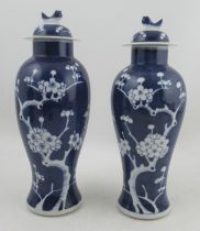 A pair of blue and white baluster covered vases, decorated with prunus blossom, height 13ins