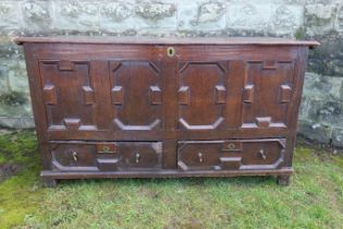 An 18th century oak mule chest, with moulded front panels, over two drawers, with a plain raising