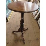 A mahogany circular topped tripod table, raised on a turned column and three outwept supports,