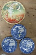 A large Eastern design pottery wall plate, together with three blue and white wall plates