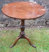 A 19th century oak tilt top tripod table, raised on a turned column, with three outswept supports,