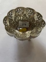 An Indian silver pierced Bowl with panels embossed trees and deities, raised on three fish