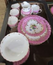 A 19th century English porcelain part service, decorated with flowers to a pink border