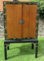 An Eastern design cabinet with painted decoration and applied gilt mounts raised on a stand, width