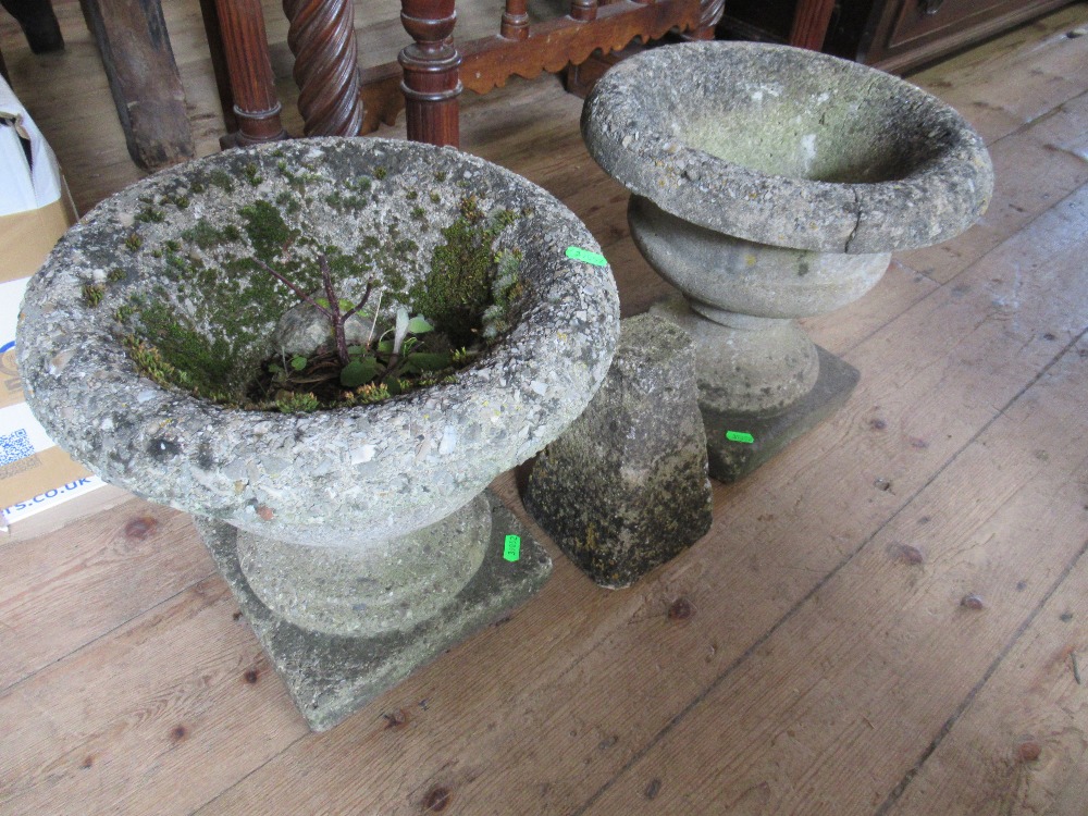 A pair of garden urns and a stone plinth