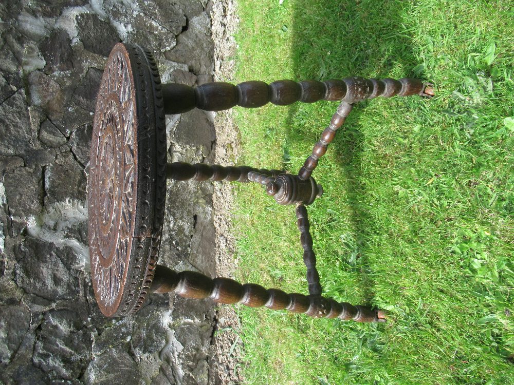 An antique oak occasional table with carved decoration