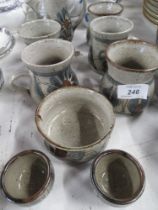 A collection of pottery tea ware decorated with flowers together with two large studio pottery mugs