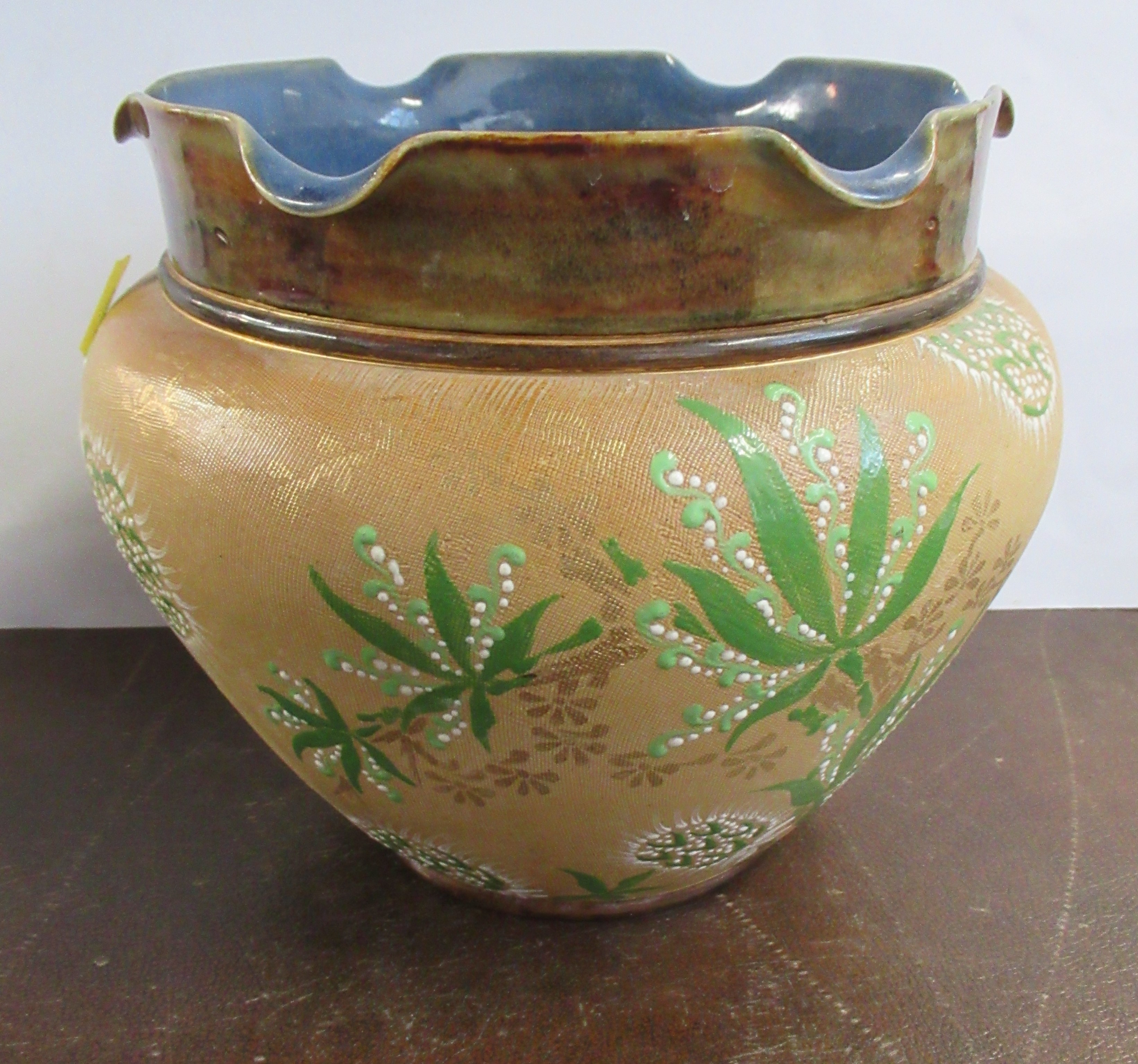 A Doulton Lambeth jardiniere, decorated in green and white to a beige ground, height 8ins