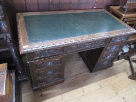 A 19th century oak twin pedestal desk, with carved decoration, width 54ins, depth 27ins, height