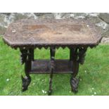 A carved oak occasional table, the top decorated with fielded panel of elephants and large raised on