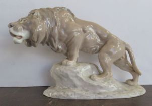 A Bing and Grondahl model, of a male lion on a rock, made before 1940, end of tail missing