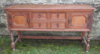 An oak sideboard, fitted with two drawers flanked by cupboards, 63ins x 18ins, height 34.5ins