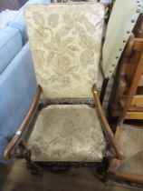 An antique open arm chair with tapestry back and seat raised on carved legs
