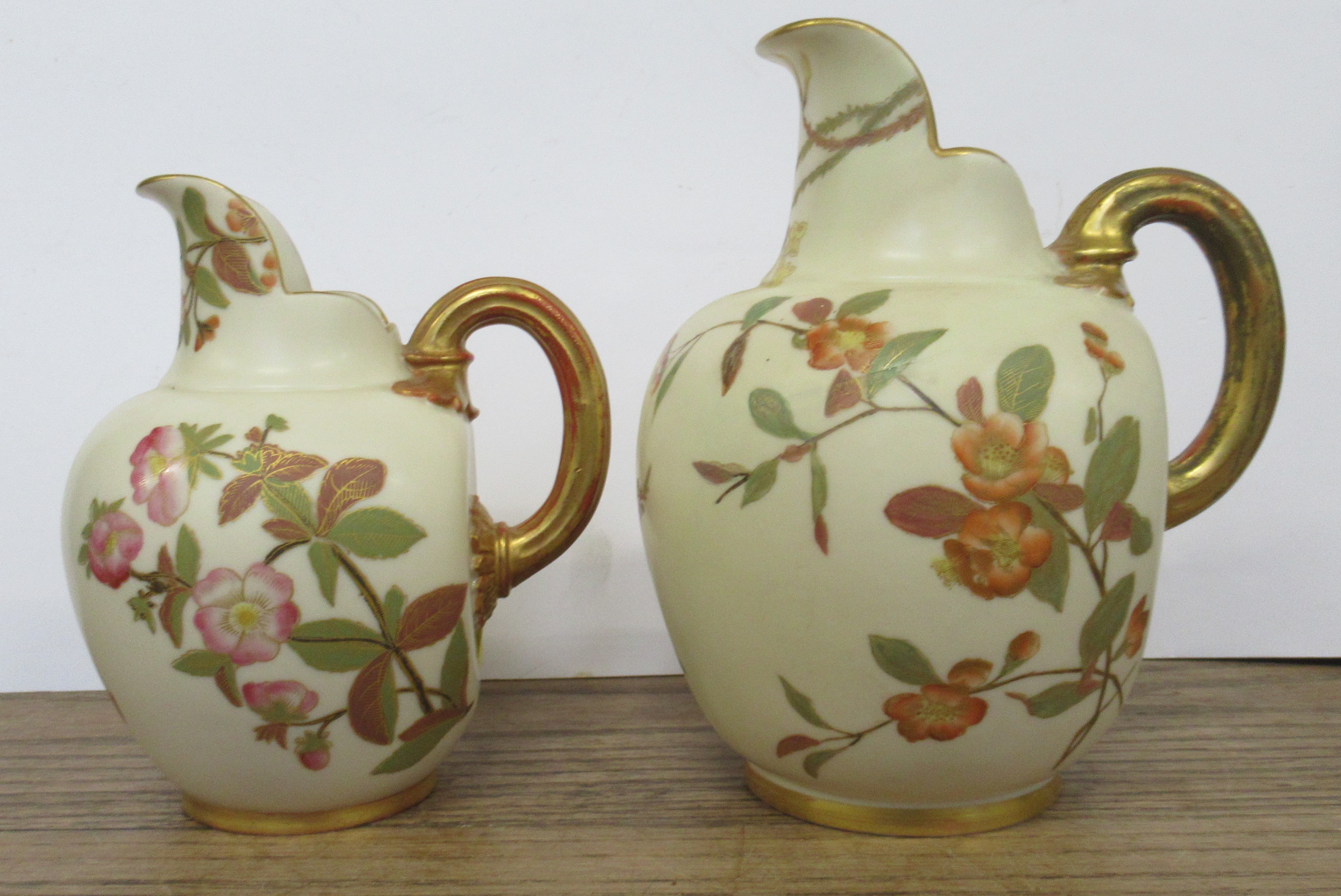 Two Royal Worcester gilt ivory flat back jugs, decorated with shot silk flowers, shape No. 1094,
