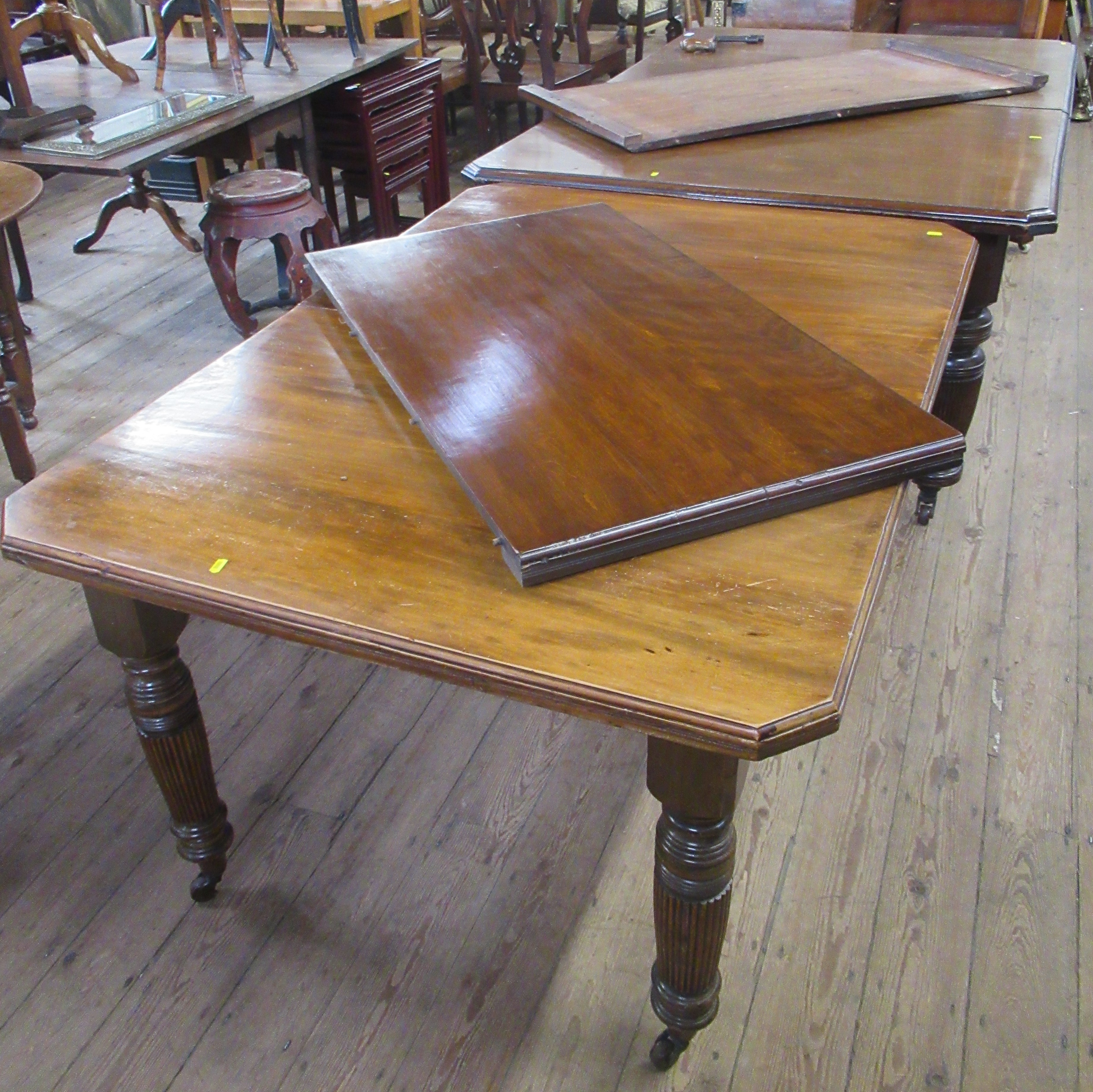Two 19th century mahogany extending dining tables, each table has an extra leaf and handle, total