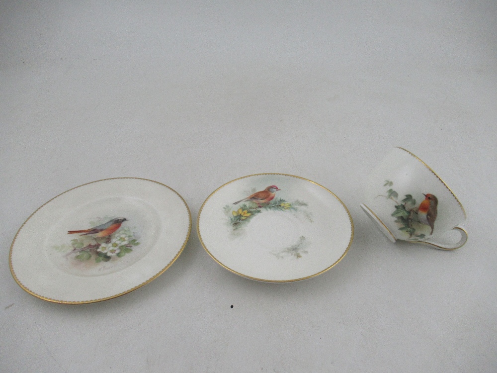 A Royal Worcester cup decorated with a robin  saucer decorated with a Linnet and side plate