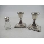 A pair of silver dwarf candlesticks, on square bases, together with a glass bottle with silver screw