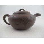 A Chinese Yixing style terracotta teapot, incised with a landscape and script, with seal mark,