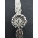 An 18K Ebel white gold lady's diamond set cocktail watch, the circular dial with baton numerals, the