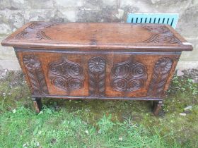 A small 18th century oak coffer of six plank construction with carved decoration width 34.5ins