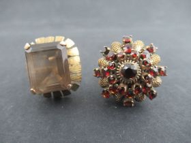 A gold ring set with a rectangular cut smokey quartz, stamped 14k and a 14k ring set with garnet