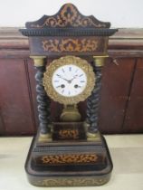 A French clock with circular enamel dial supported by four turned columns with marquetery frieze and