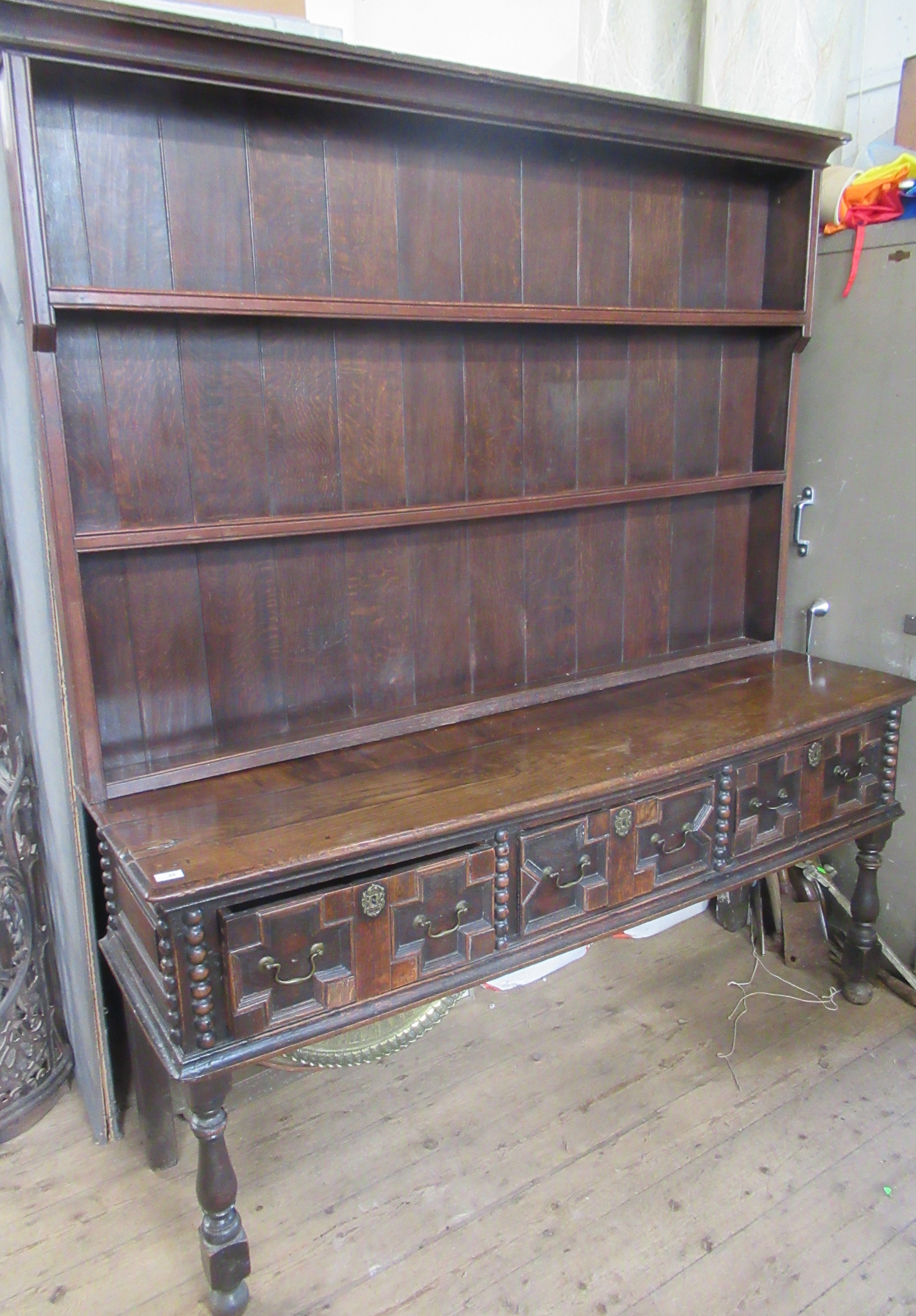 An Antique oak dresser, with boarded plate rack over, the base having moulded drawer fronts, width