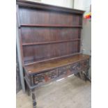 An Antique oak dresser, with boarded plate rack over, the base having moulded drawer fronts, width