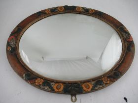 An oval mirror, having a painted and carved frame, with beveled plate, width 24ins