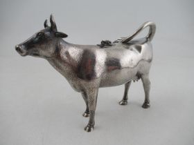 A Victorian silver cow creamer, modelled as a cow with fly on its back, London 1862, maker George