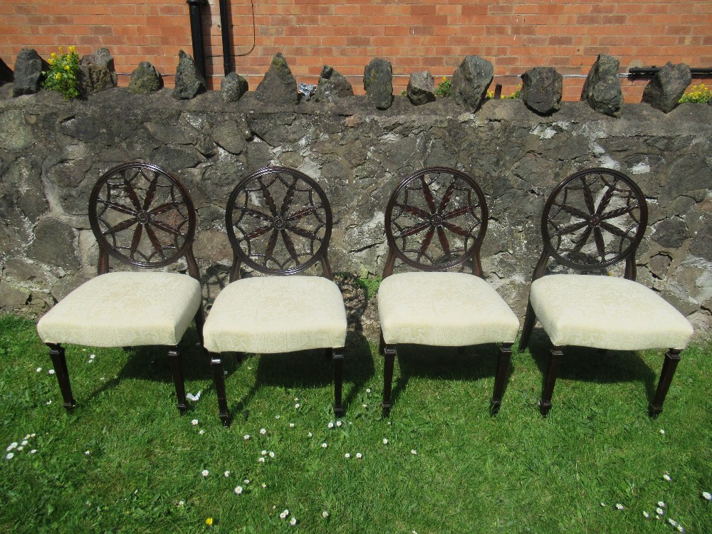 A set of four 18th/19th century mahogany dining chairs, in the Hepplewhite style,  with circular