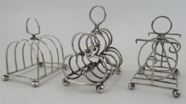 Three silver five bar toast racks, one with bars forming letters TOAST, weight 6oz