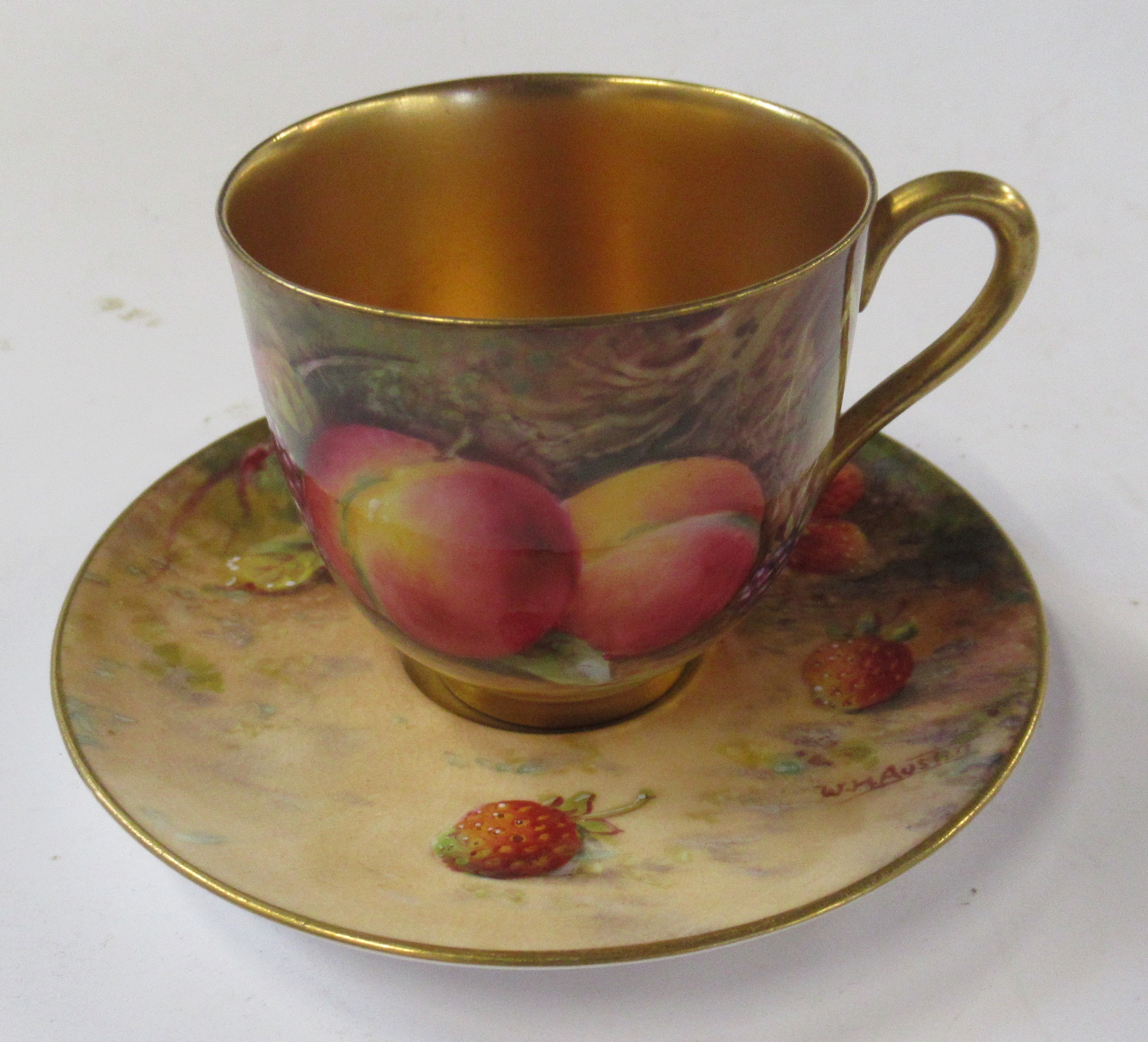 A Royal Worcester cabinet cup and saucer, decorated with fruit to a mossy background, the cup by E