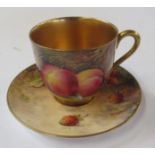 A Royal Worcester cabinet cup and saucer, decorated with fruit to a mossy background, the cup by E