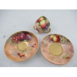 Three pieces of Royal Worcester, a cup and two saucers, all decorated with fruit to a mossy