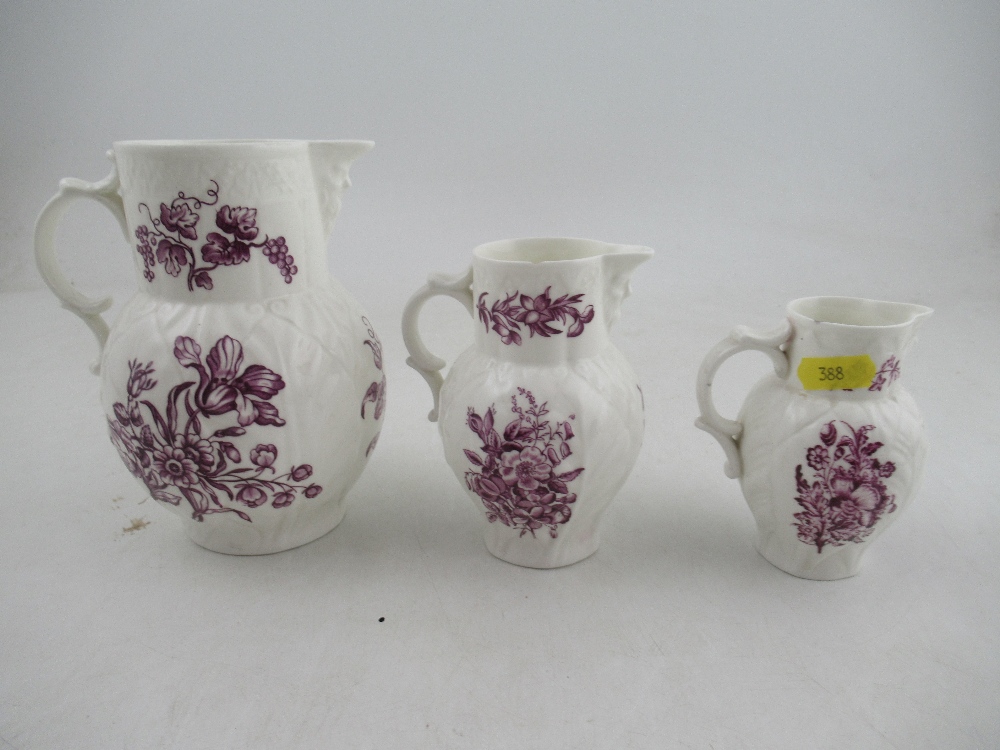 A set of three graduated Royal Worcester jugs decorated with purple flowers to a white ground